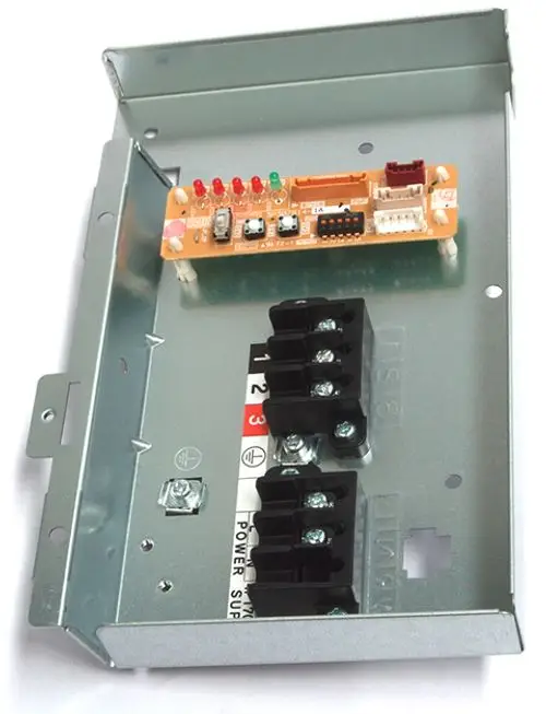 Daikin Abdeckung mit Klemmleiste in einem Metallgehäuse, ausgestattet mit einer Leiterplatte und mehreren Anschlussklemmen für elektrische Verbindungen.